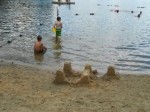 Sand castle and children swimming