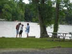 People standing near treees and lake