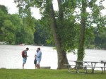 People standing near treees and lake